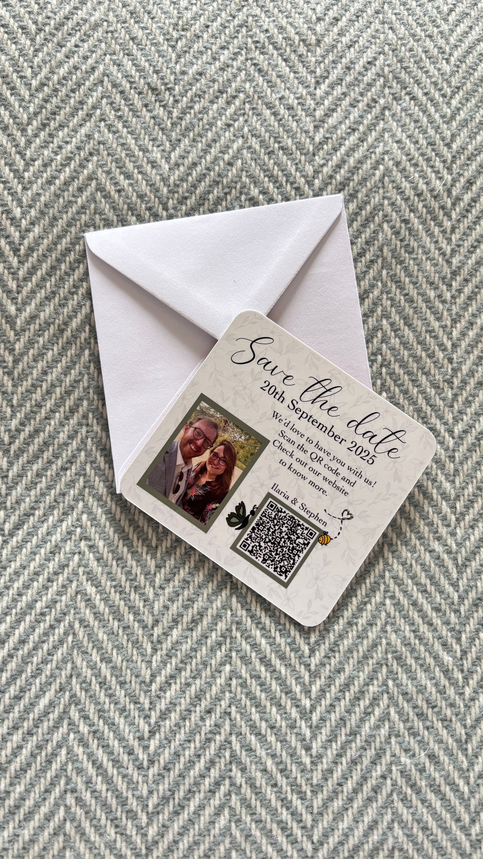 Square save the date magnet card with a couple's photo and a QR code, on a white envelope